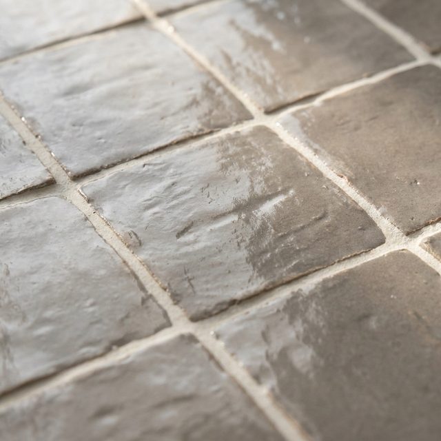 Handmade warm grey ceramic wall tile with uneven glossy faces